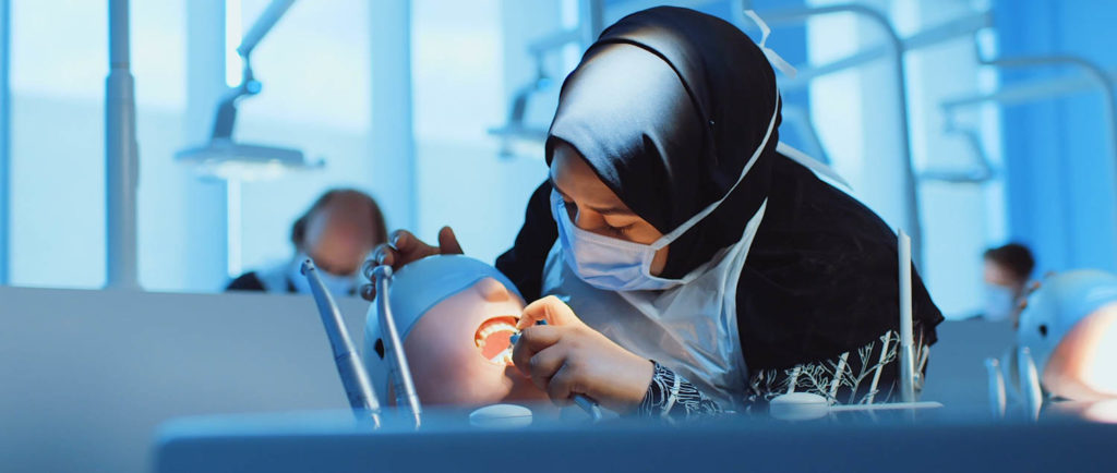 dental student working on a practise dental head