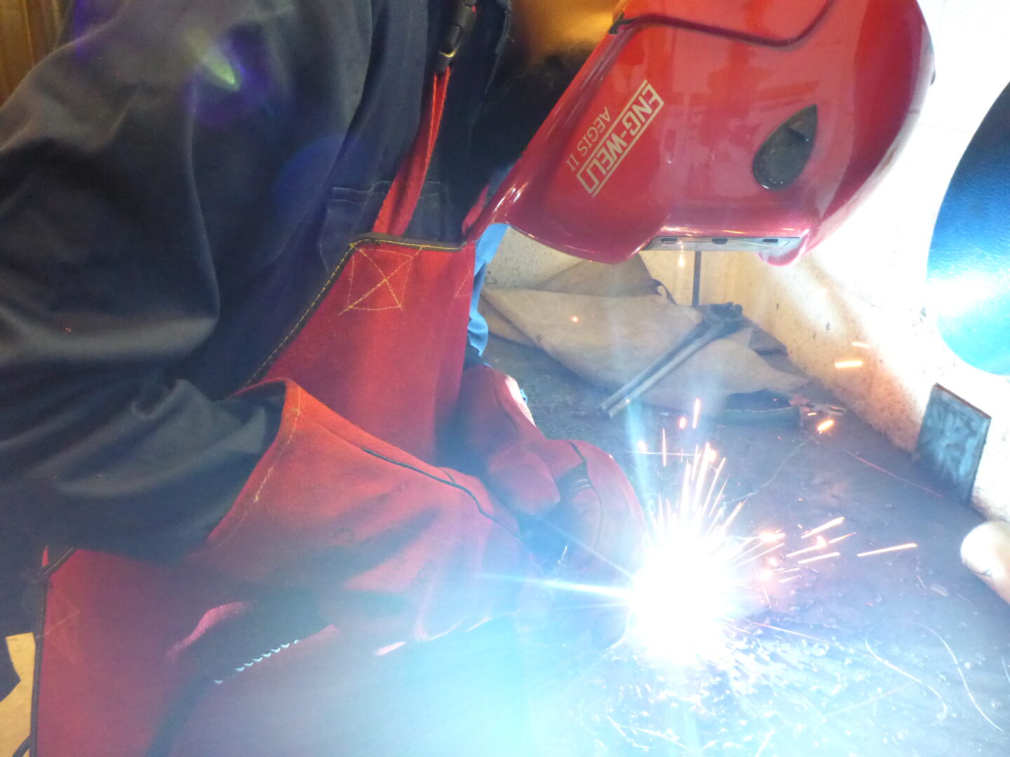 welding student welding a piece of metal as sparks fly