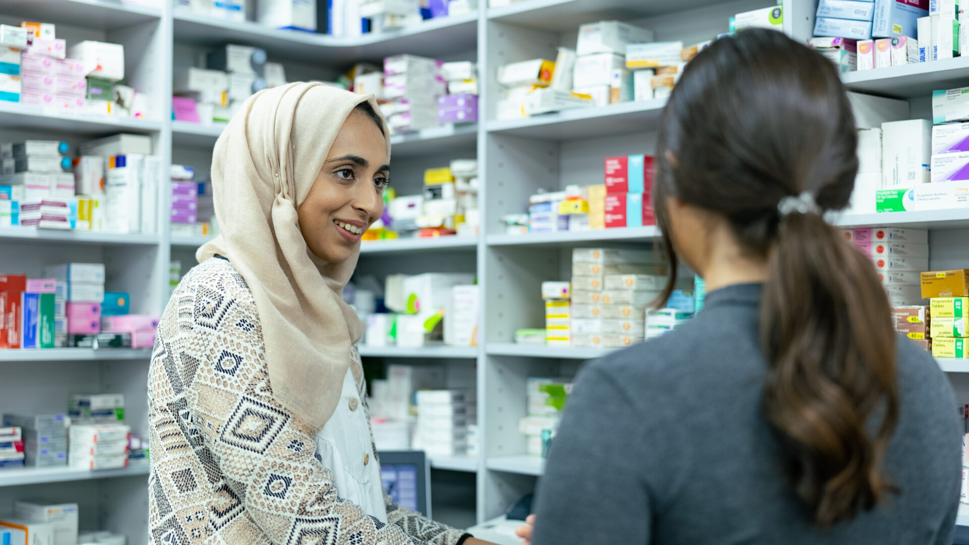 2 female infront of pharmacy medication