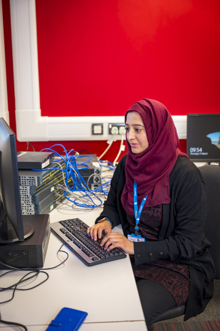 female computing student sat working at a computer screen