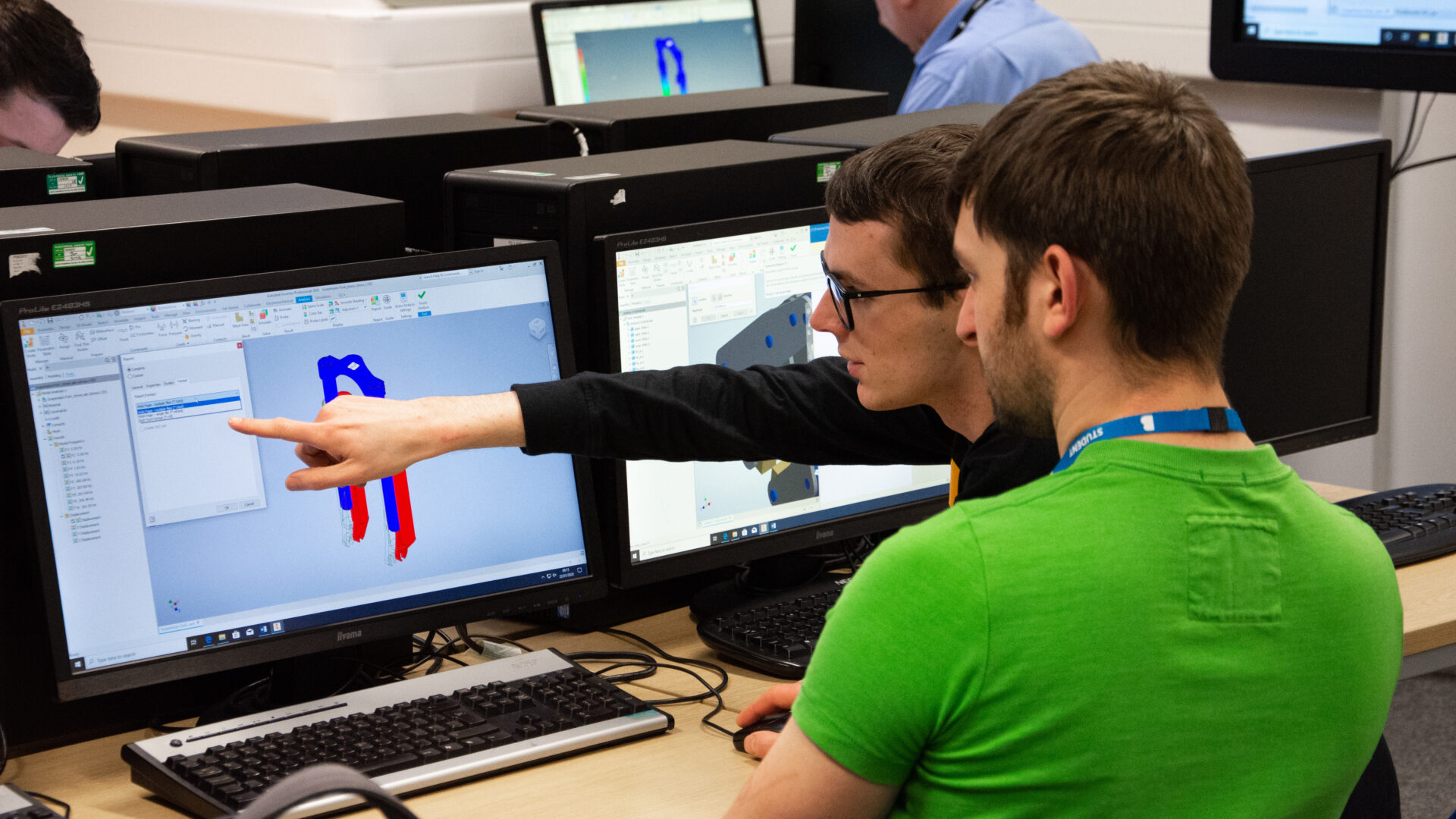 cad parametric modelling students discussing a design on a computer screen