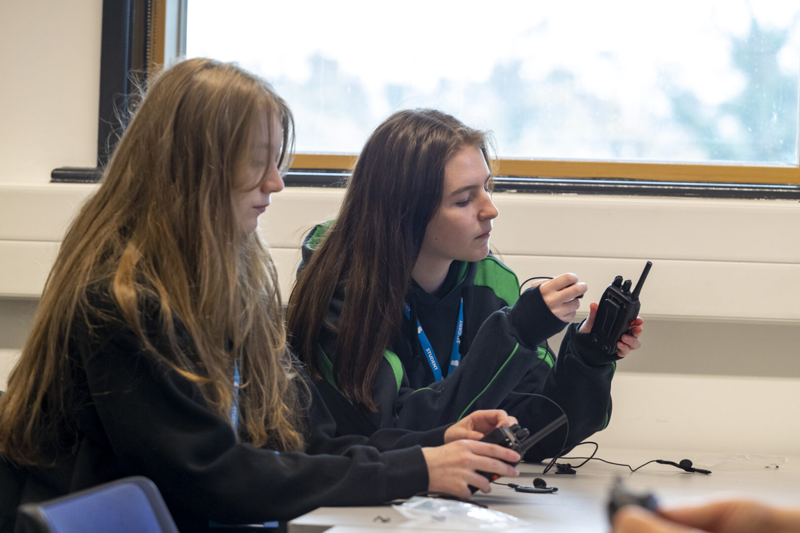 uniformed services students sat at a desk security radio