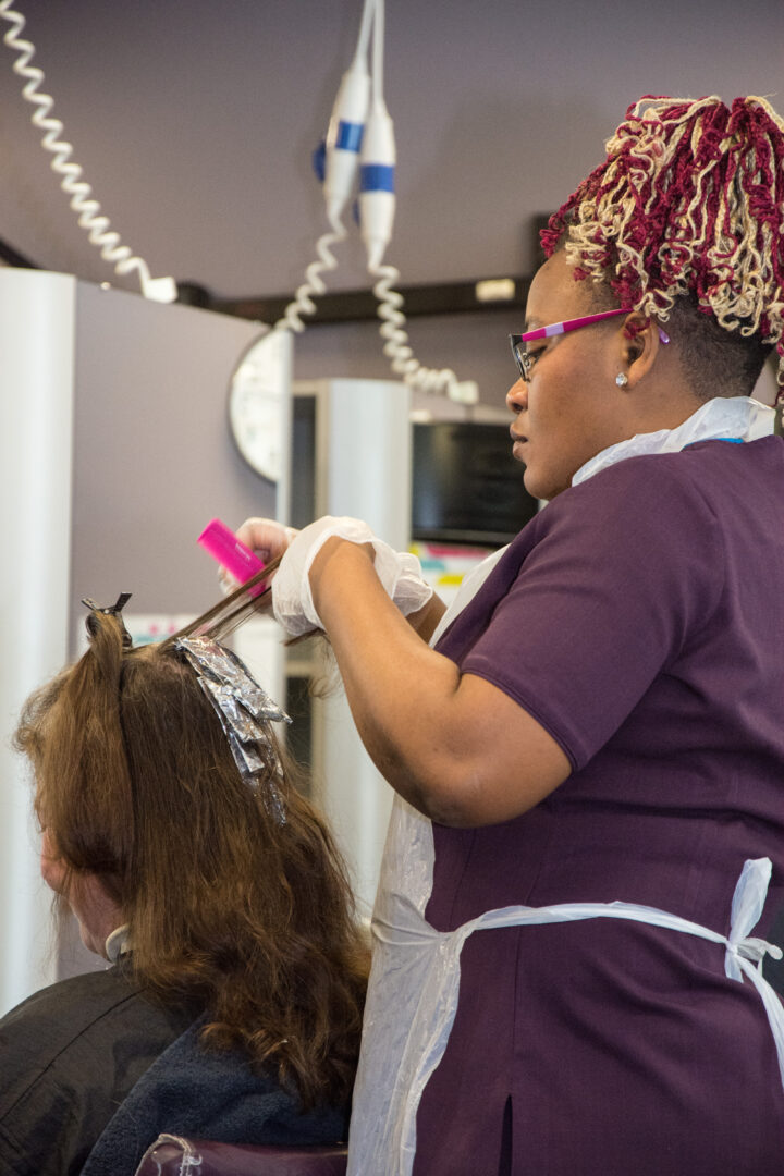 hairdressing student dyeing the hair of a hair model