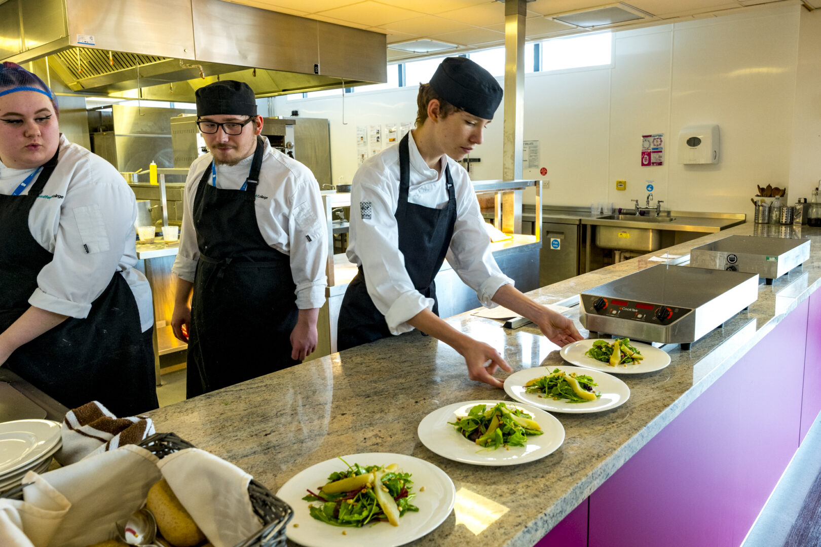 three catering students preparing and serving food at the grove cafe and bar