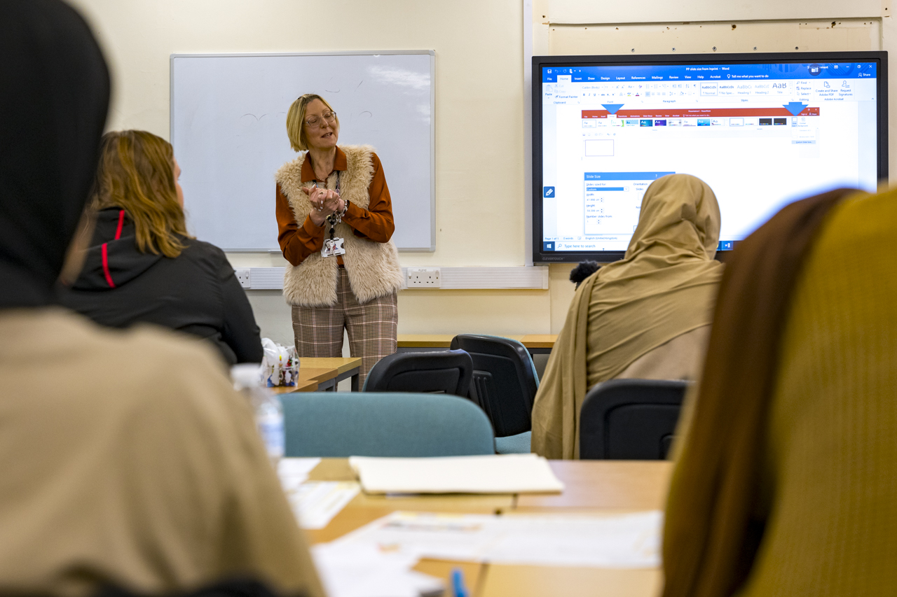 an image of a teacher teaching a classroom of students