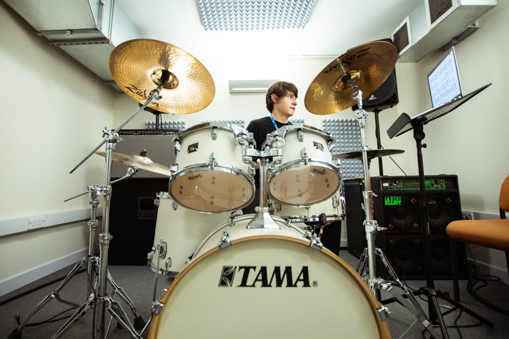 music student on a drumkit in a studio