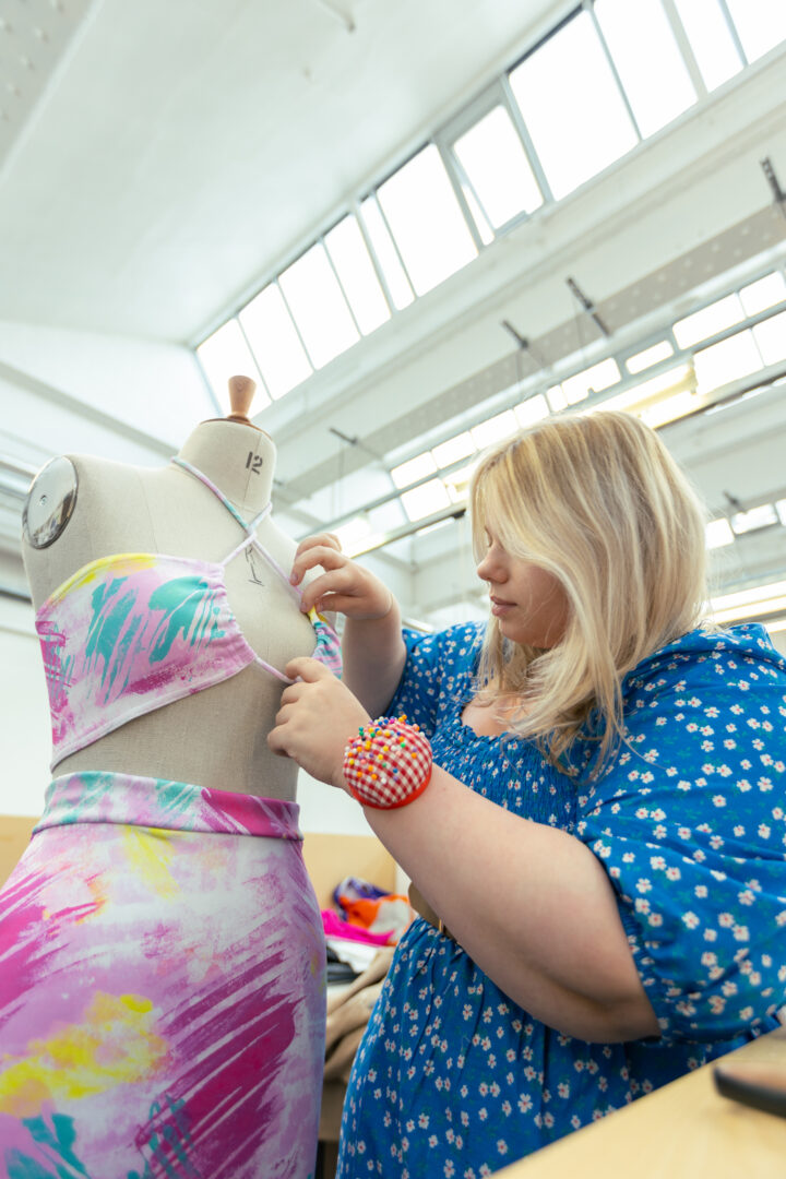fashion student pinning together an outfit to a mannequin