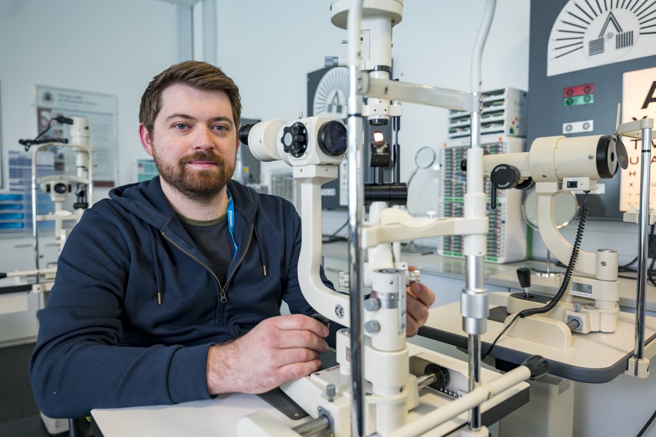 ophthalmic student sat using optic equipment