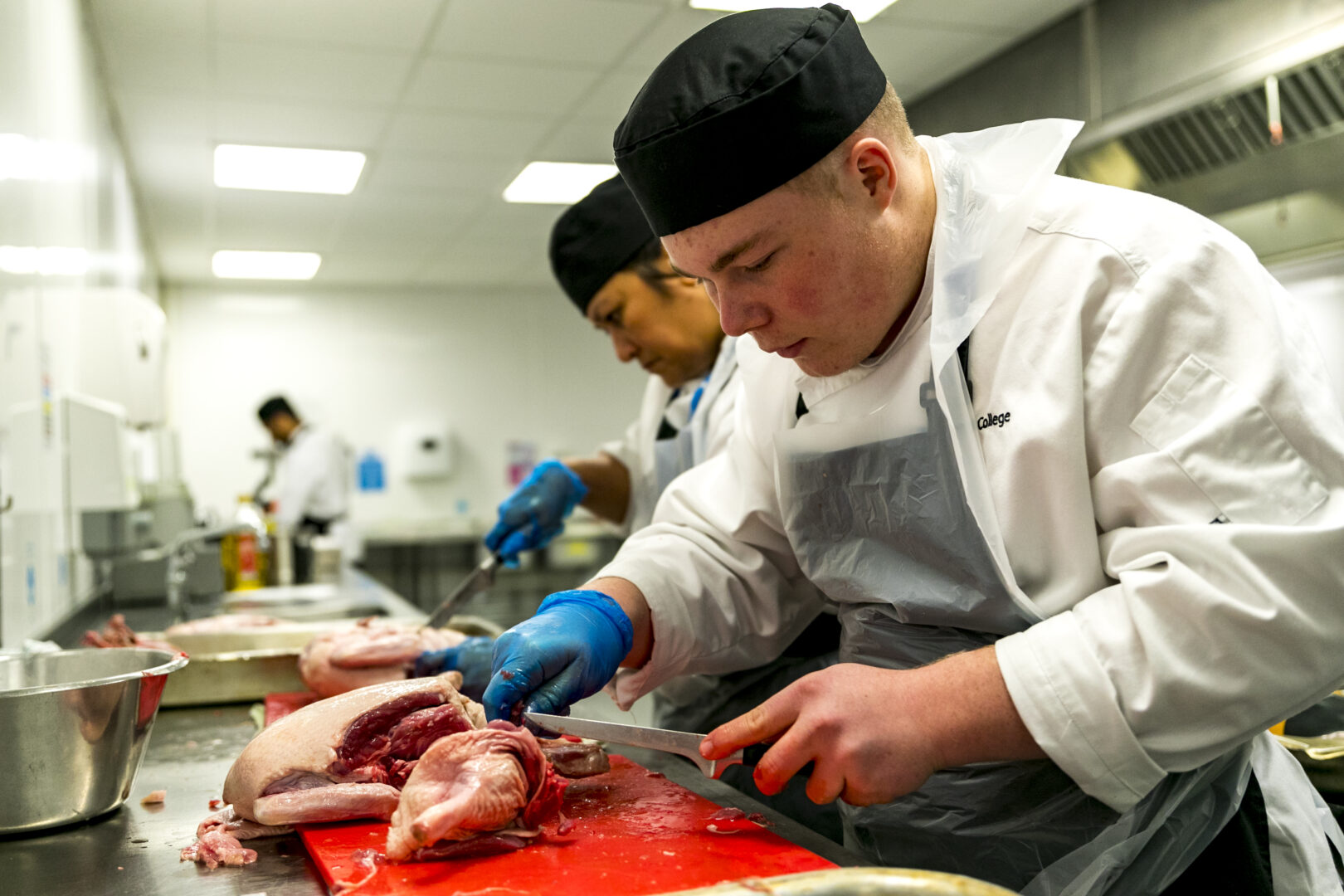 catering and hospitality students cutting meat