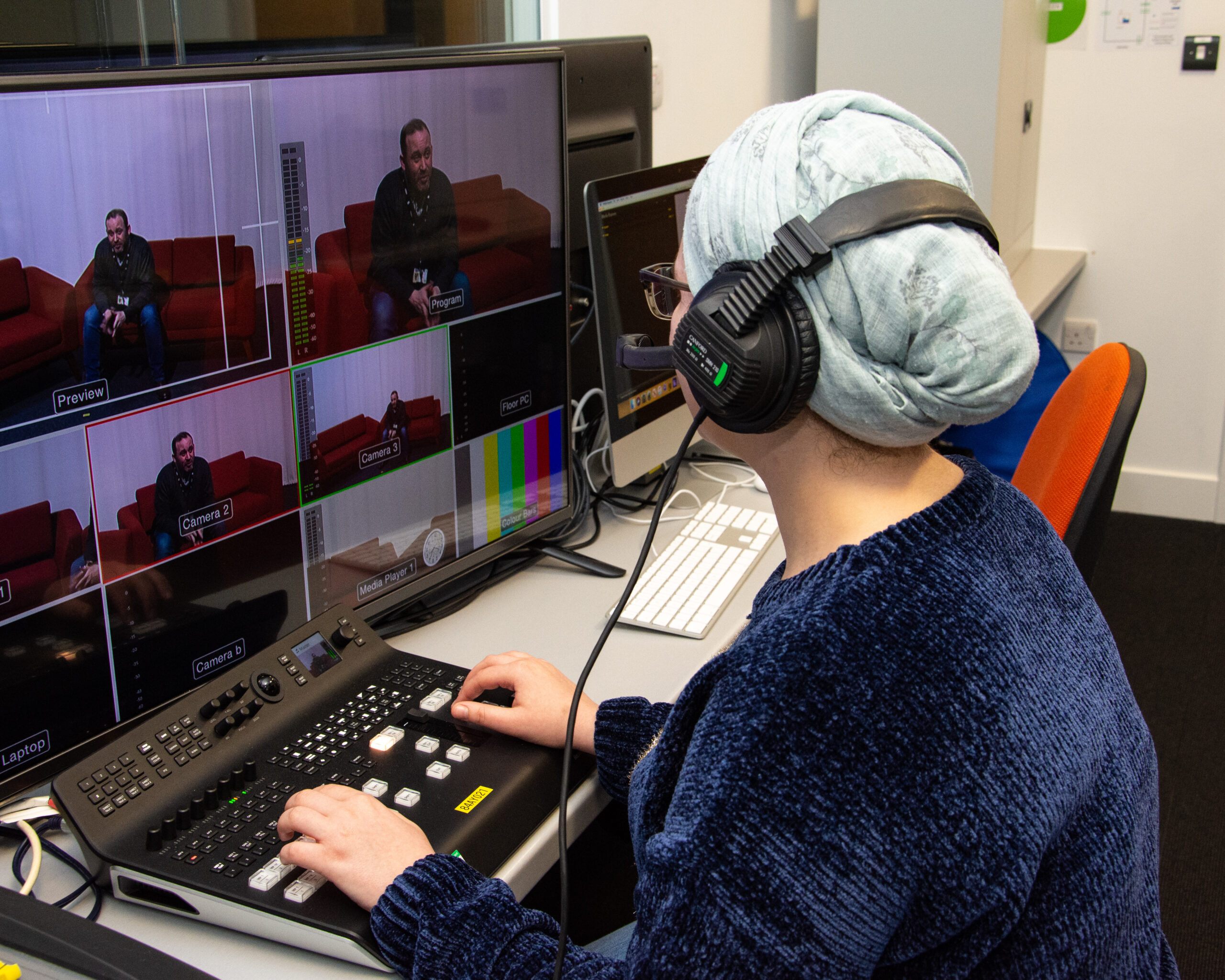 production student sat in a tv studio at a screen editing