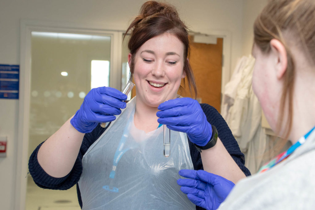 health student holding two test tubes