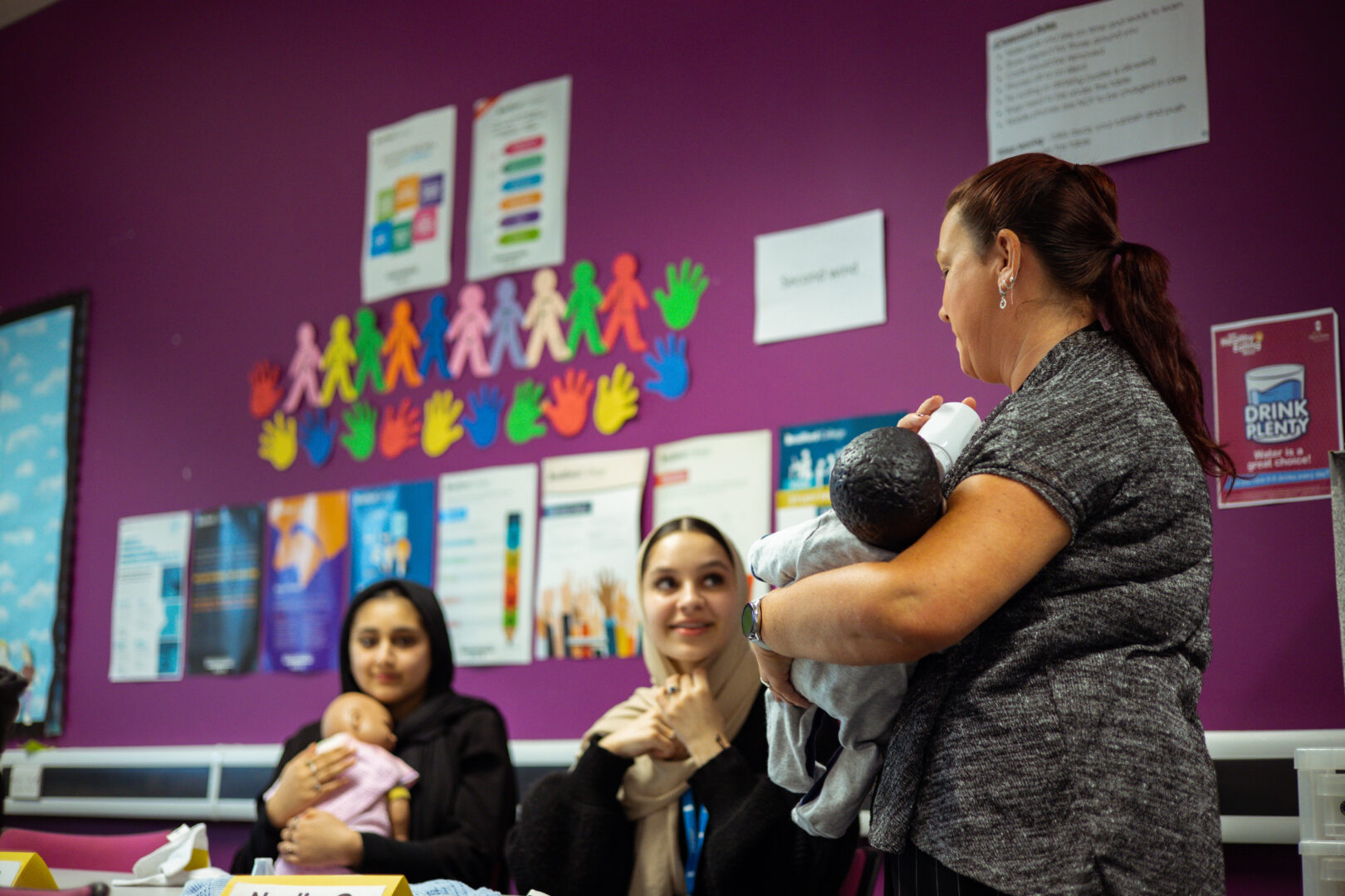 childcare students holding baby dolls