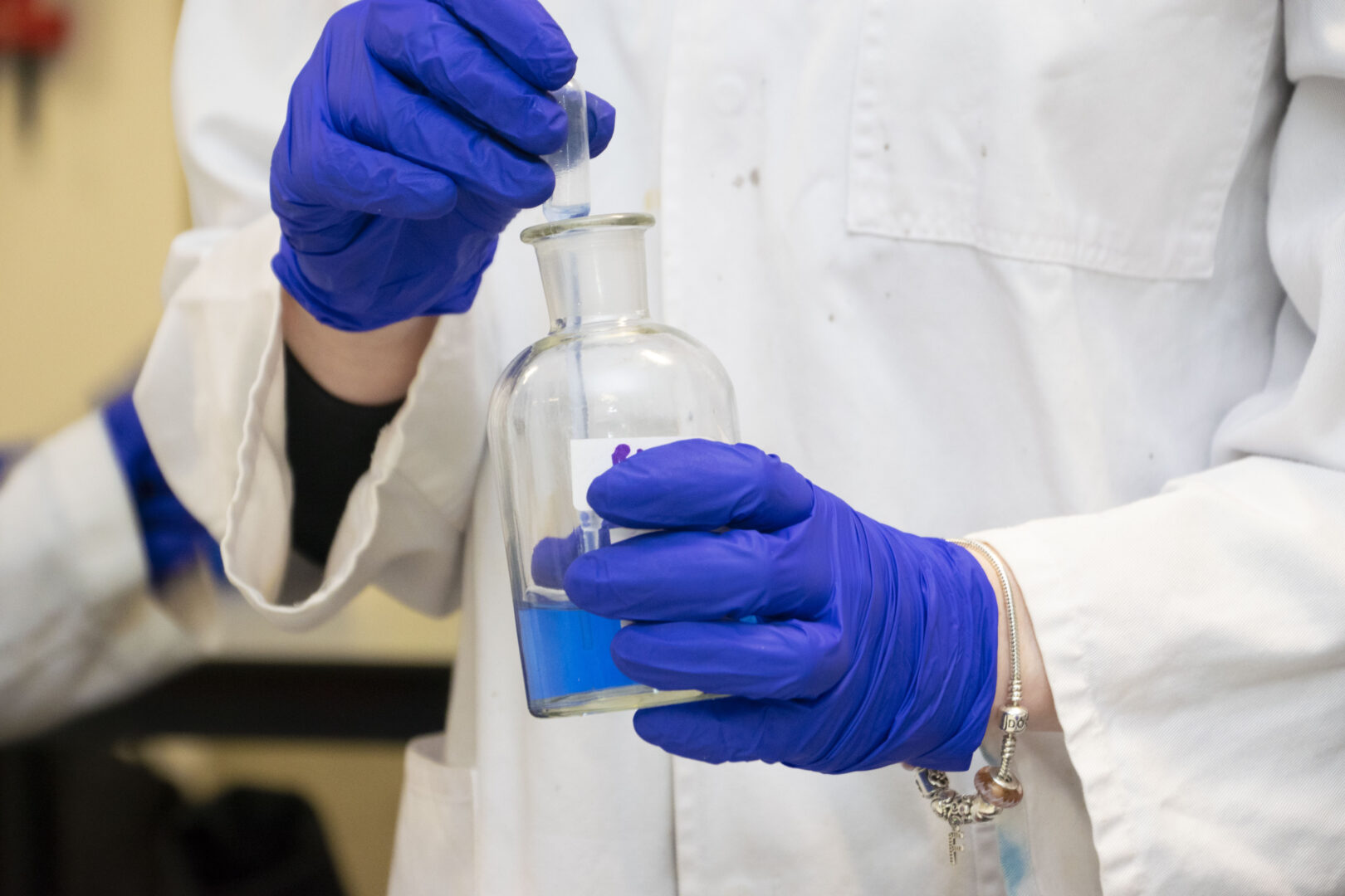 science student holding a beaker and a pipette