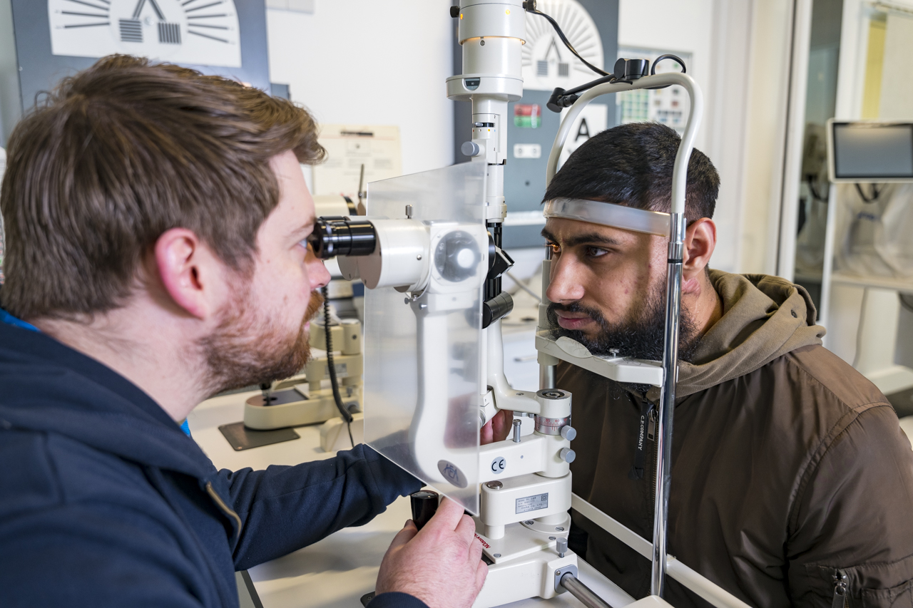opthalmic dispensing student using equipment to perform an eye test