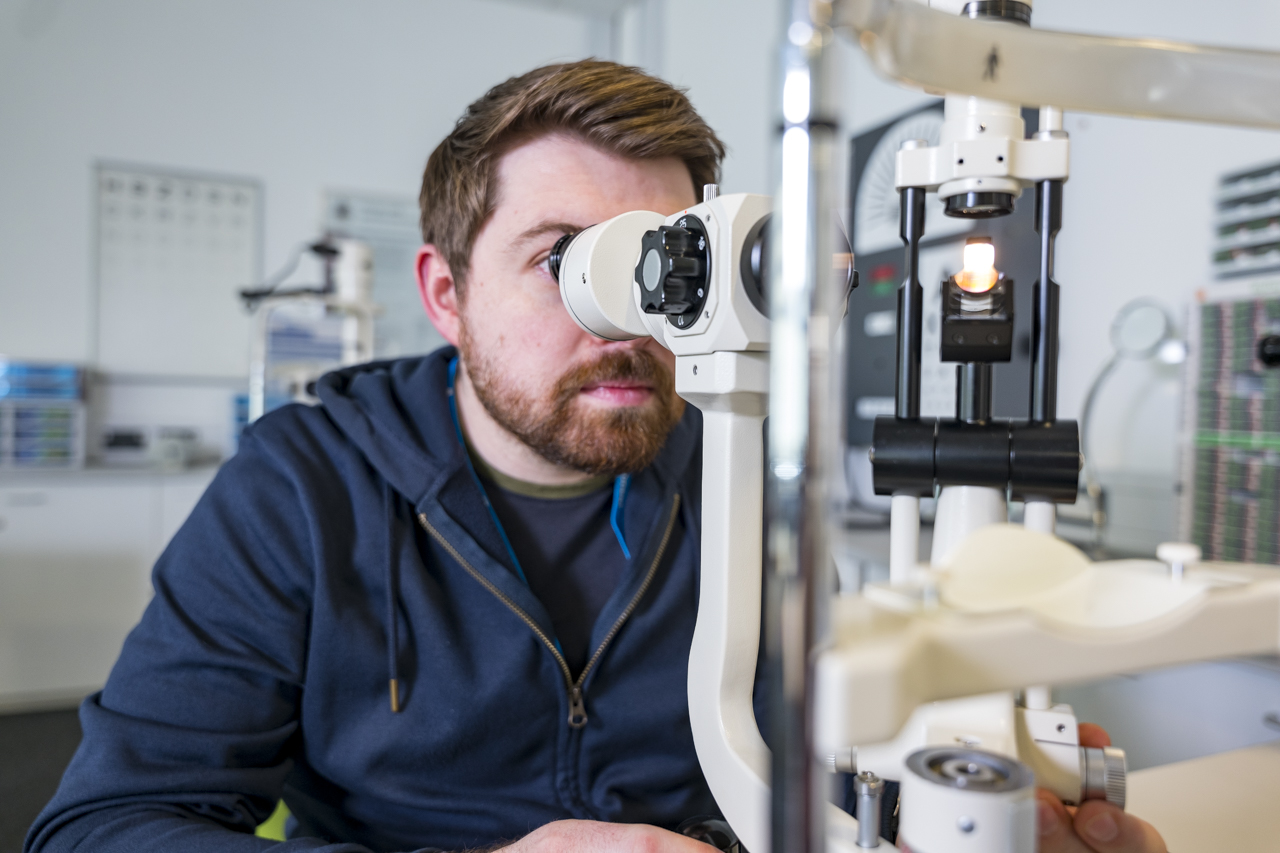 ophthalmic student sat using optic equipment