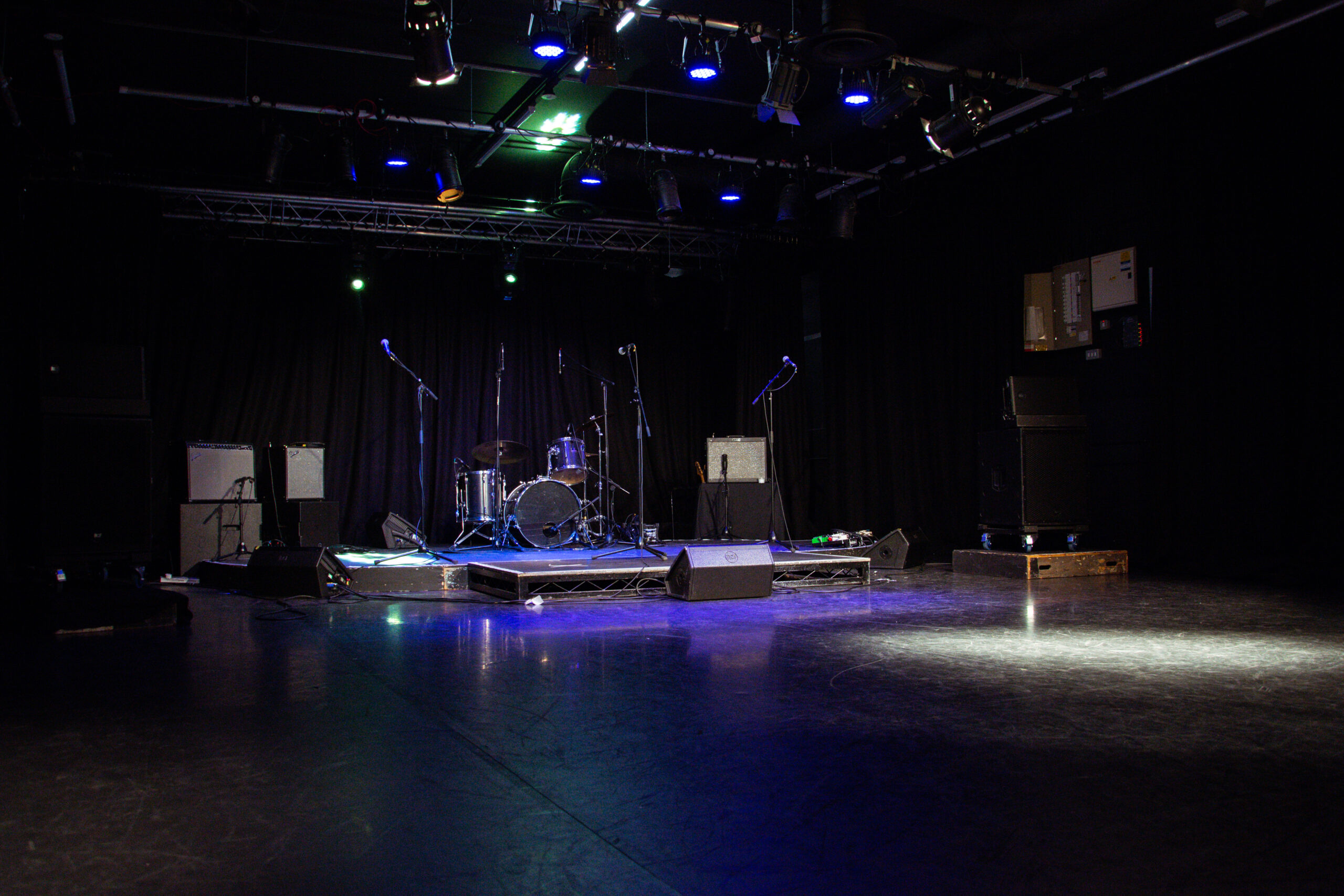 the performing arts studio facilities showing a drumkit and set of microphones as well as a sound system