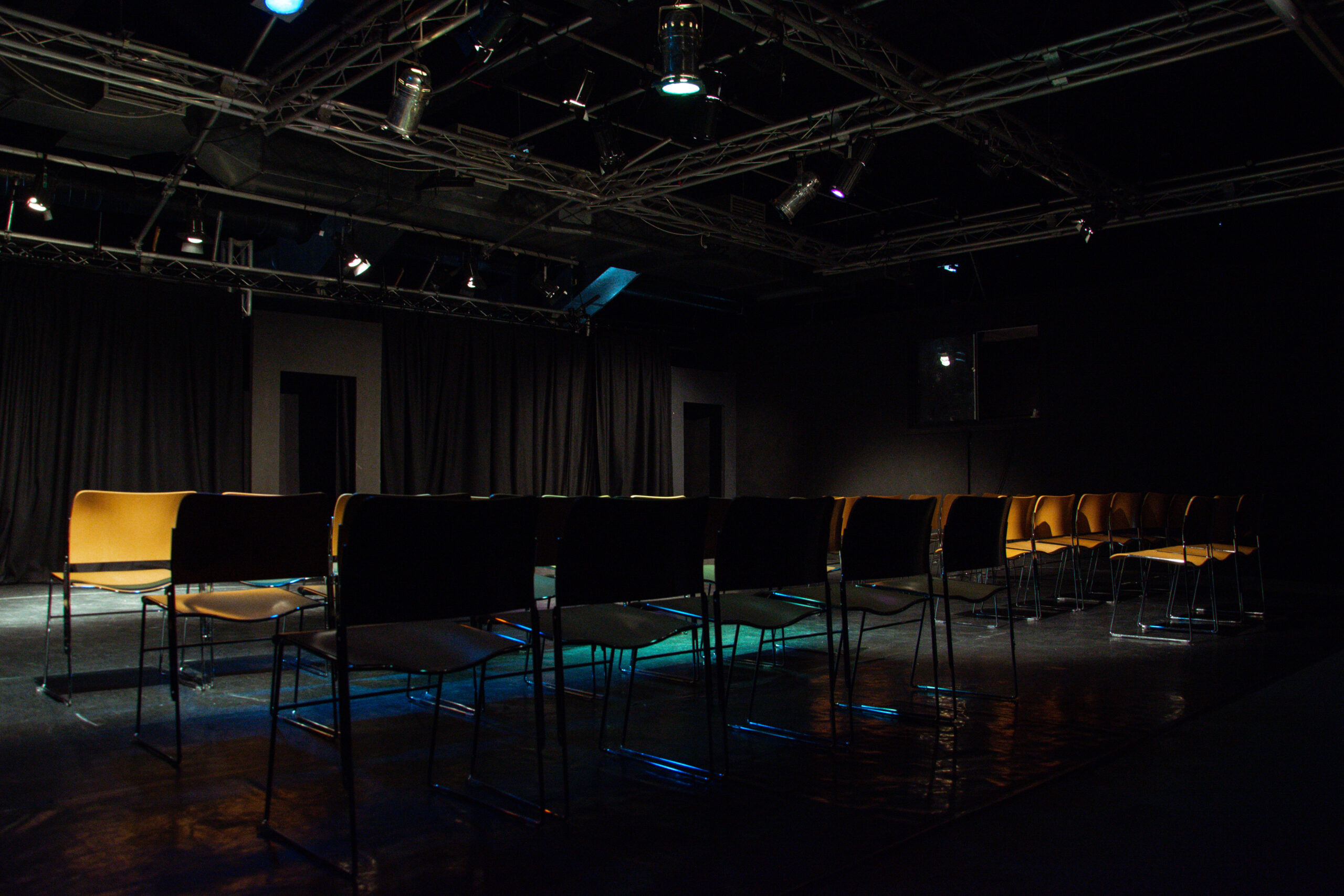 performing and music performance space set up with chairs and illuminated with lighting