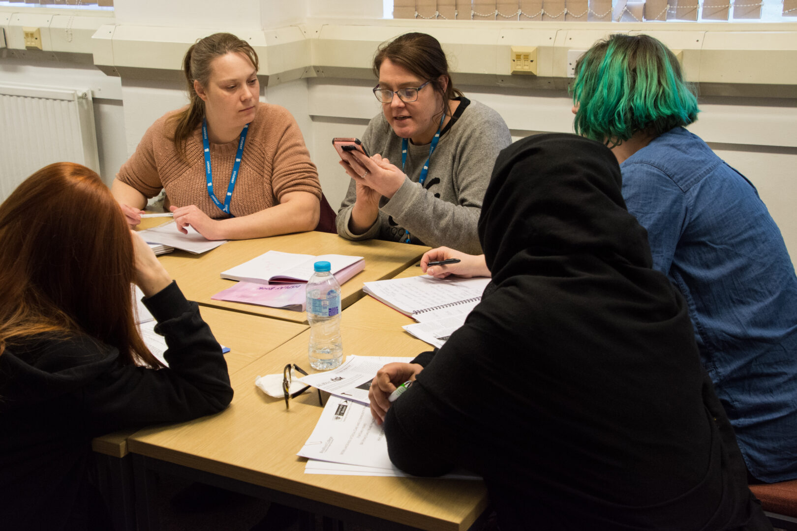 a group of students sat at a desk discussing ideas