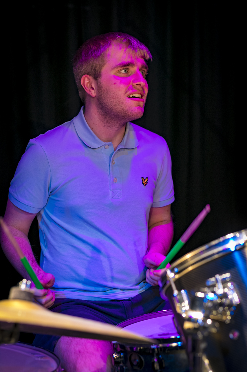 a music student sat at a drum kit performing