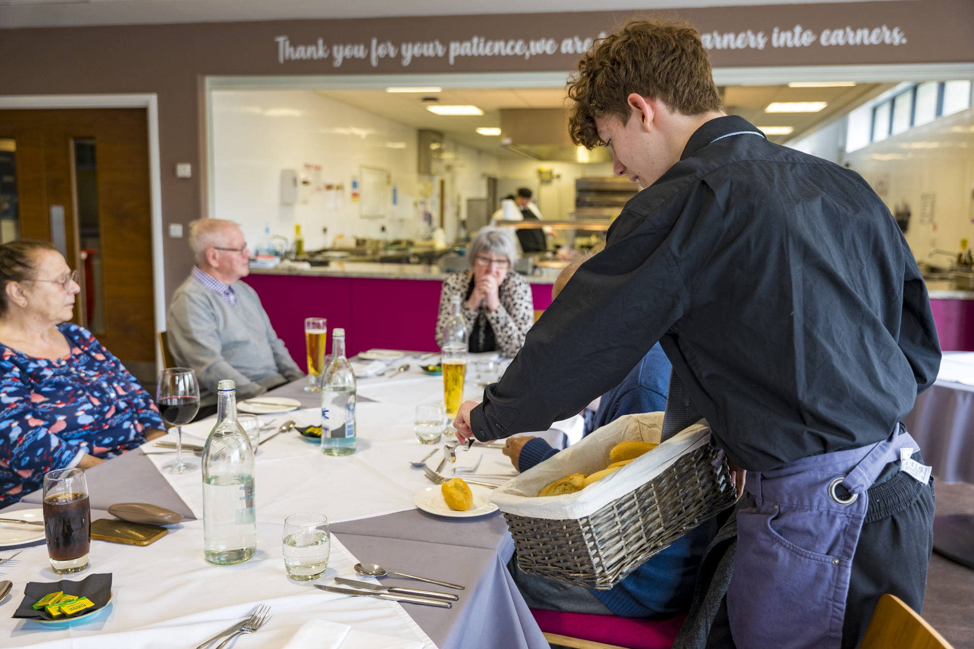 catering student serving bread in the grove restaurant