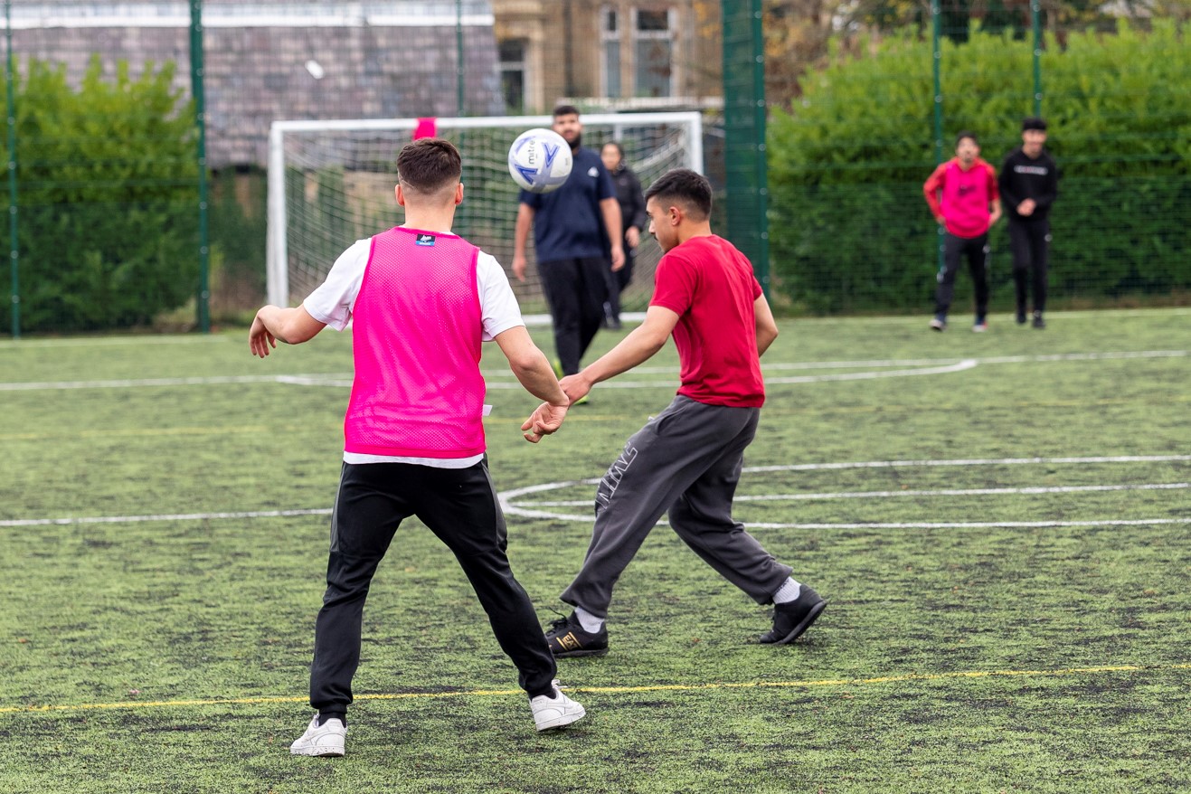 two sports students playing a game of football