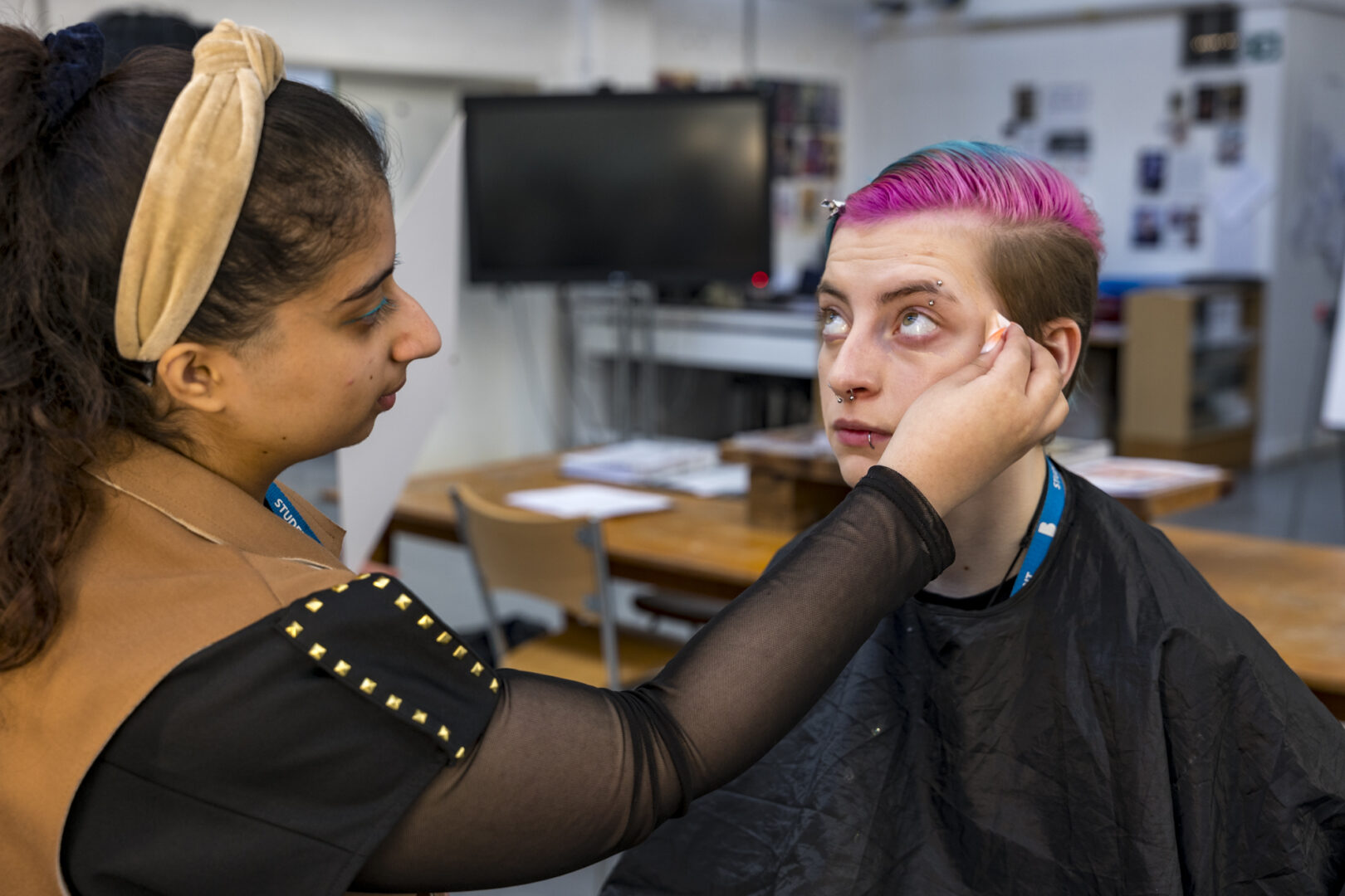 a media makeup student applying make up to a model