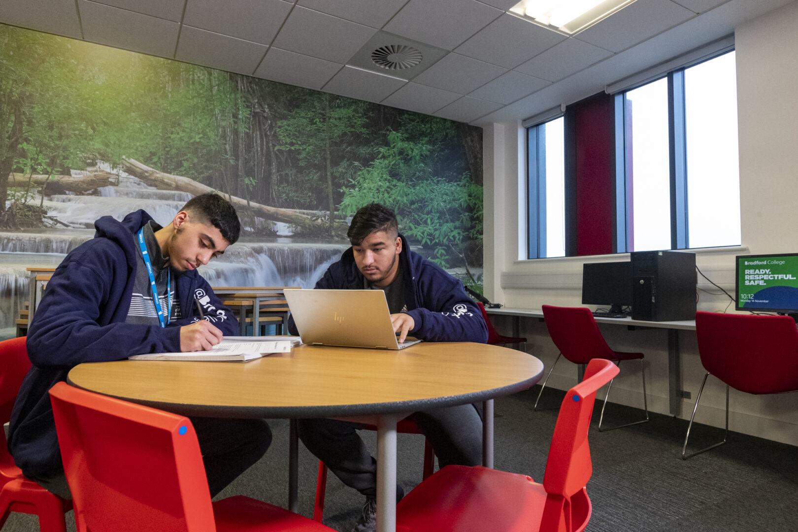 two A Level students sat at a desk working