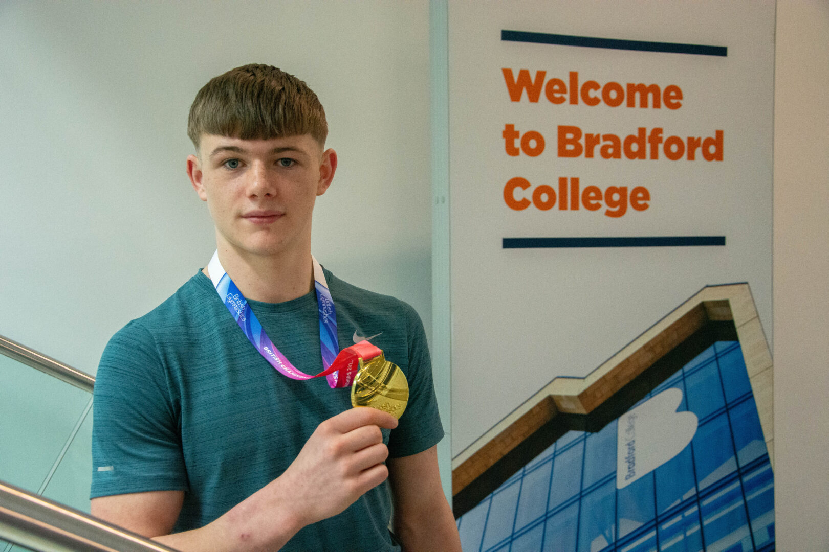 Bradford College student, Patrick Watkinson, National U18 Champion in Pommel Horse holding a gold medal.