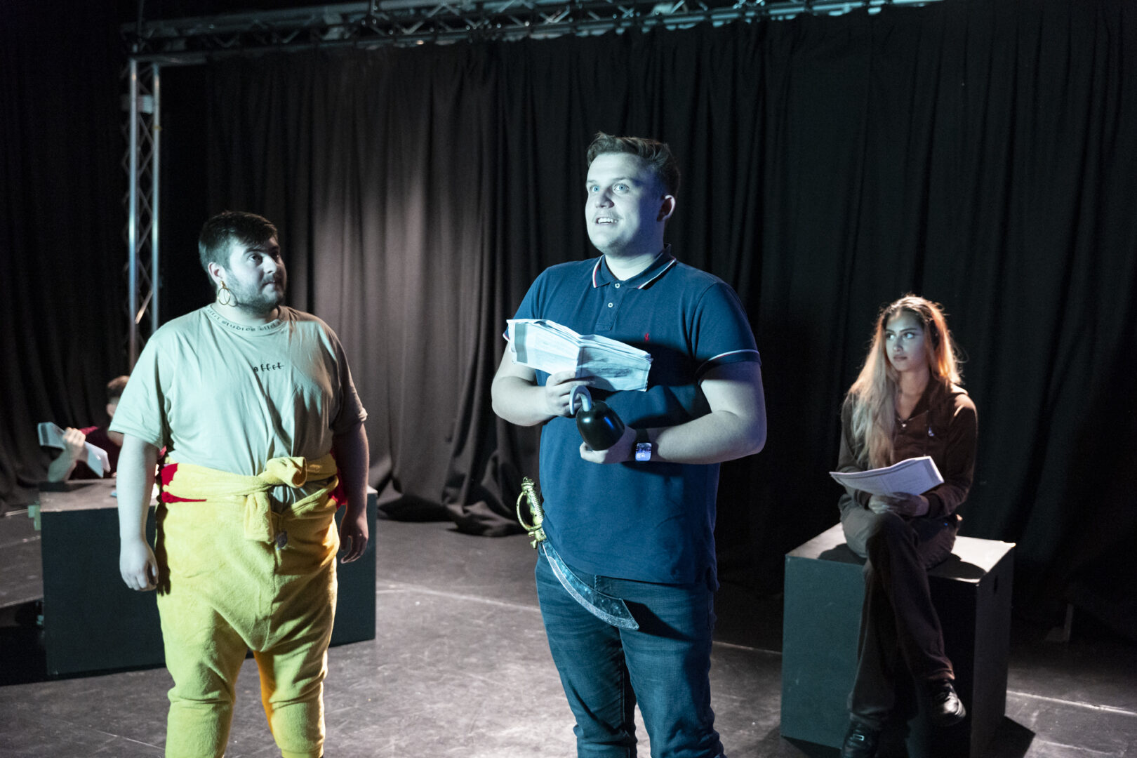 three performance students stood in the performance space rehearsing
