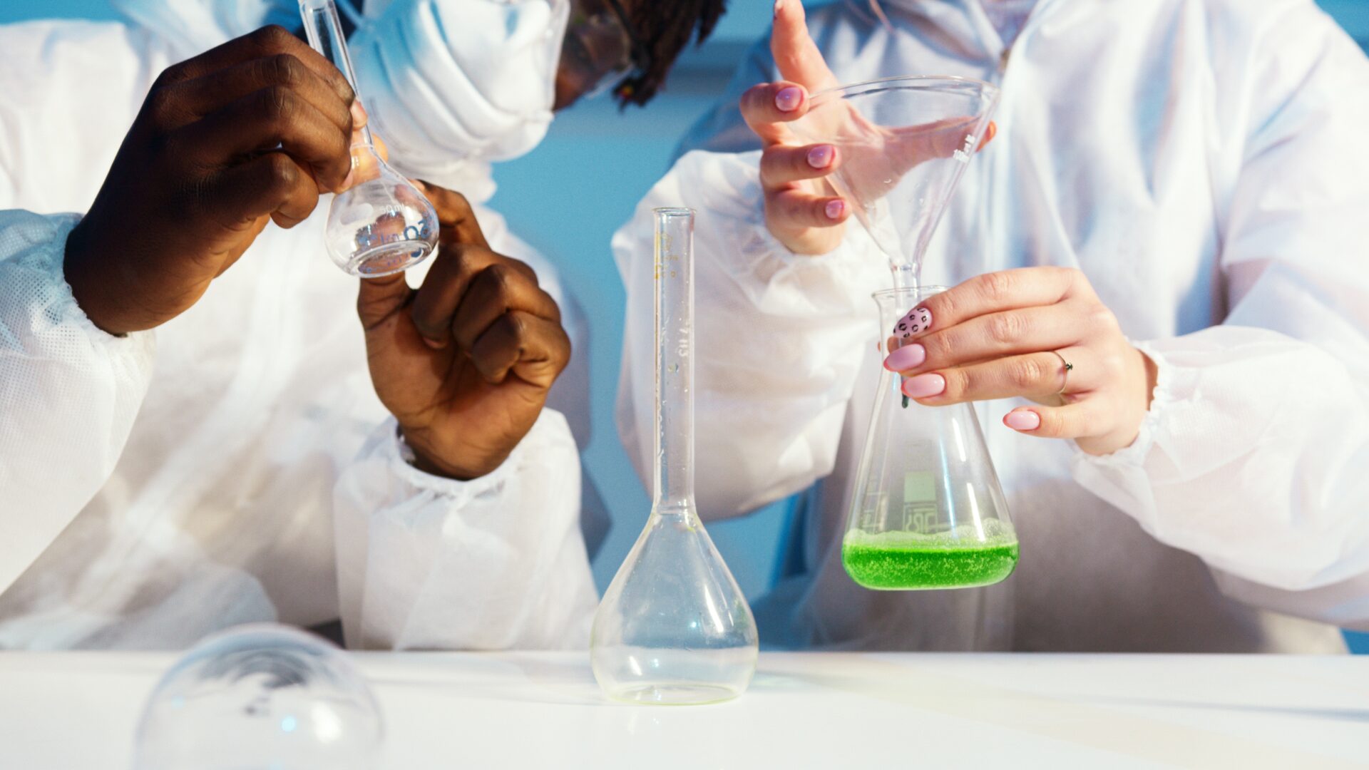 two science students holding test tubes filled with liquid