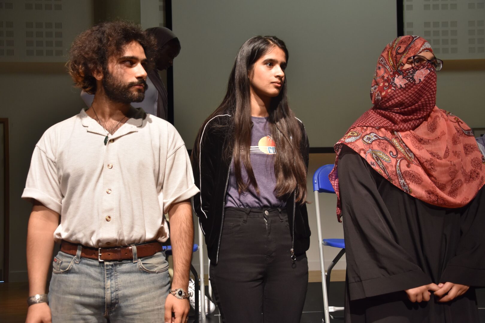 a group of 3 esol students stood performing