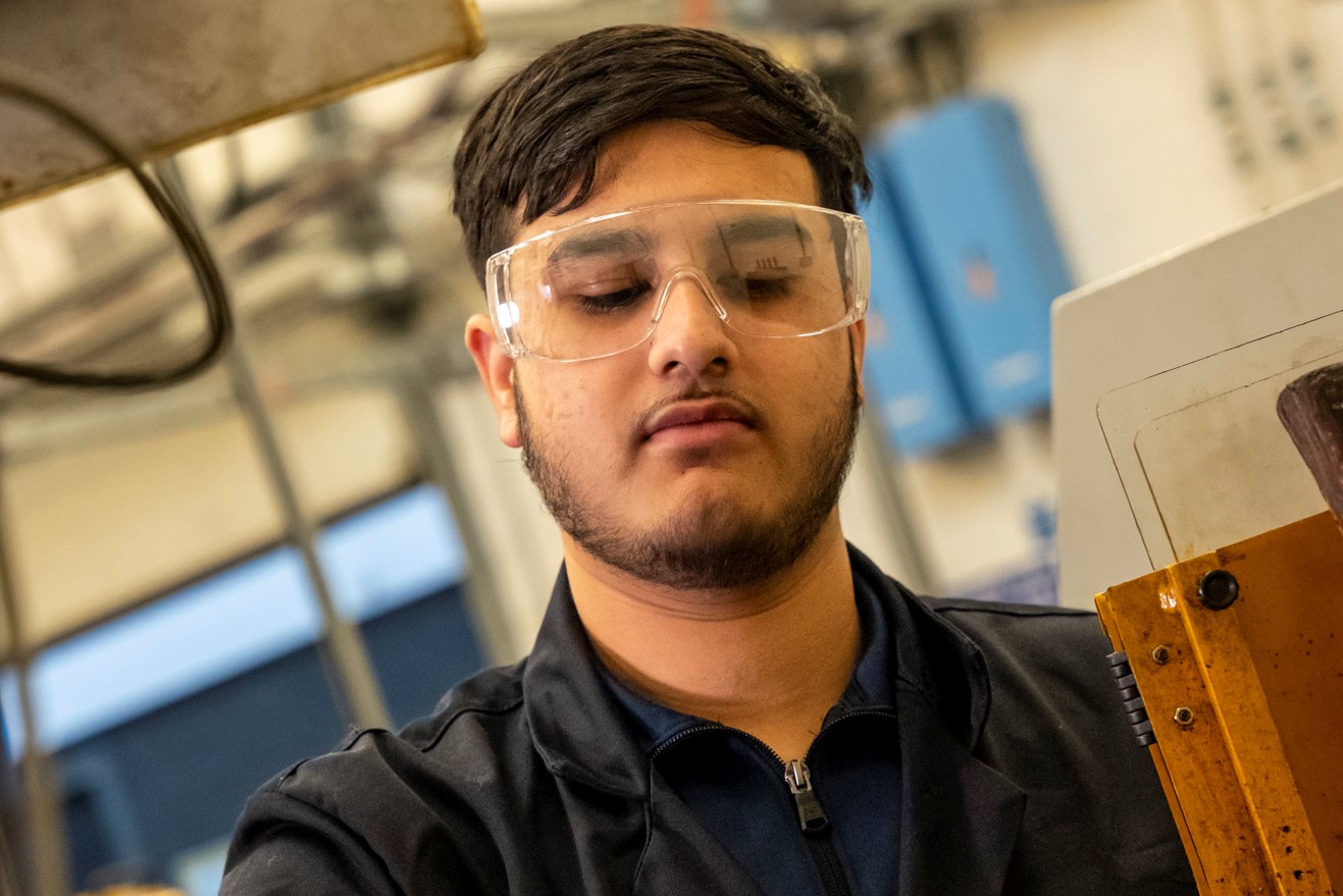 plumbing student wearing safety glasses working in the plumbing workshop