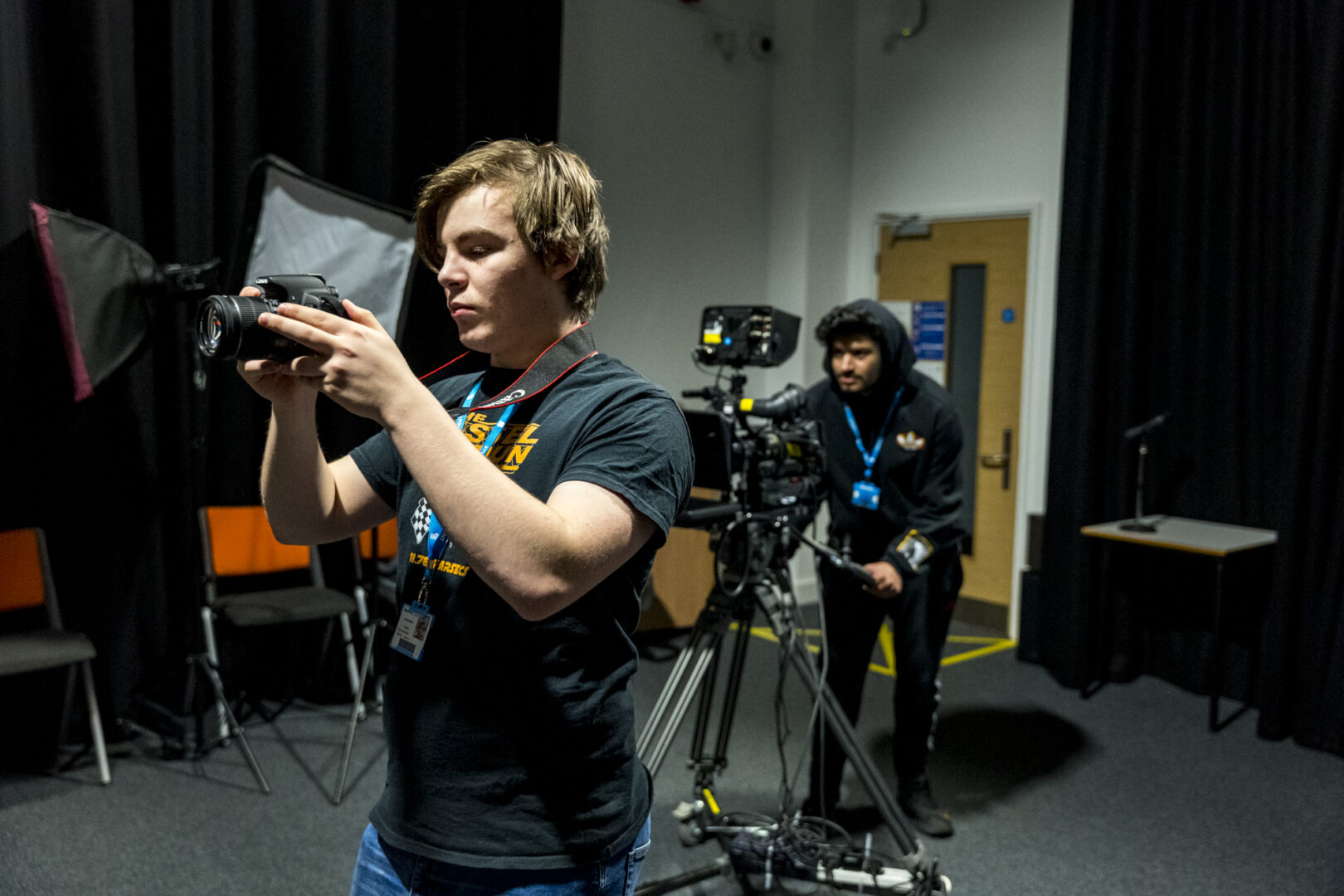 two students using camera equipment in the filming studio
