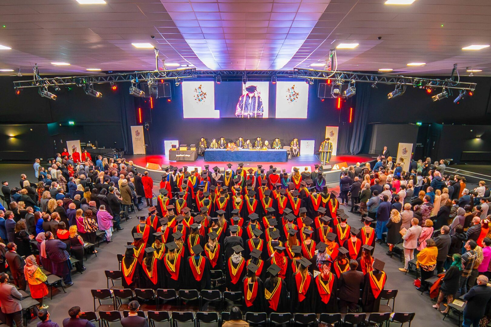a graduation hall full of graduating students all wearing cap and gowns