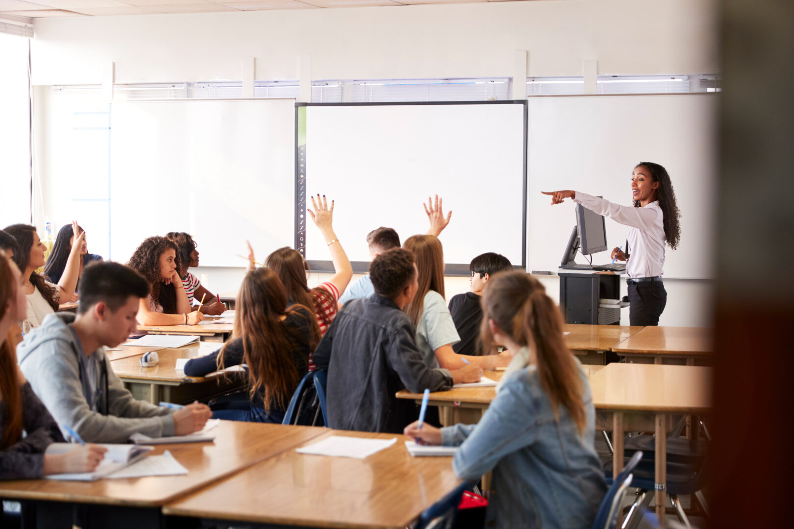 Teacher asking class a question with hands in air