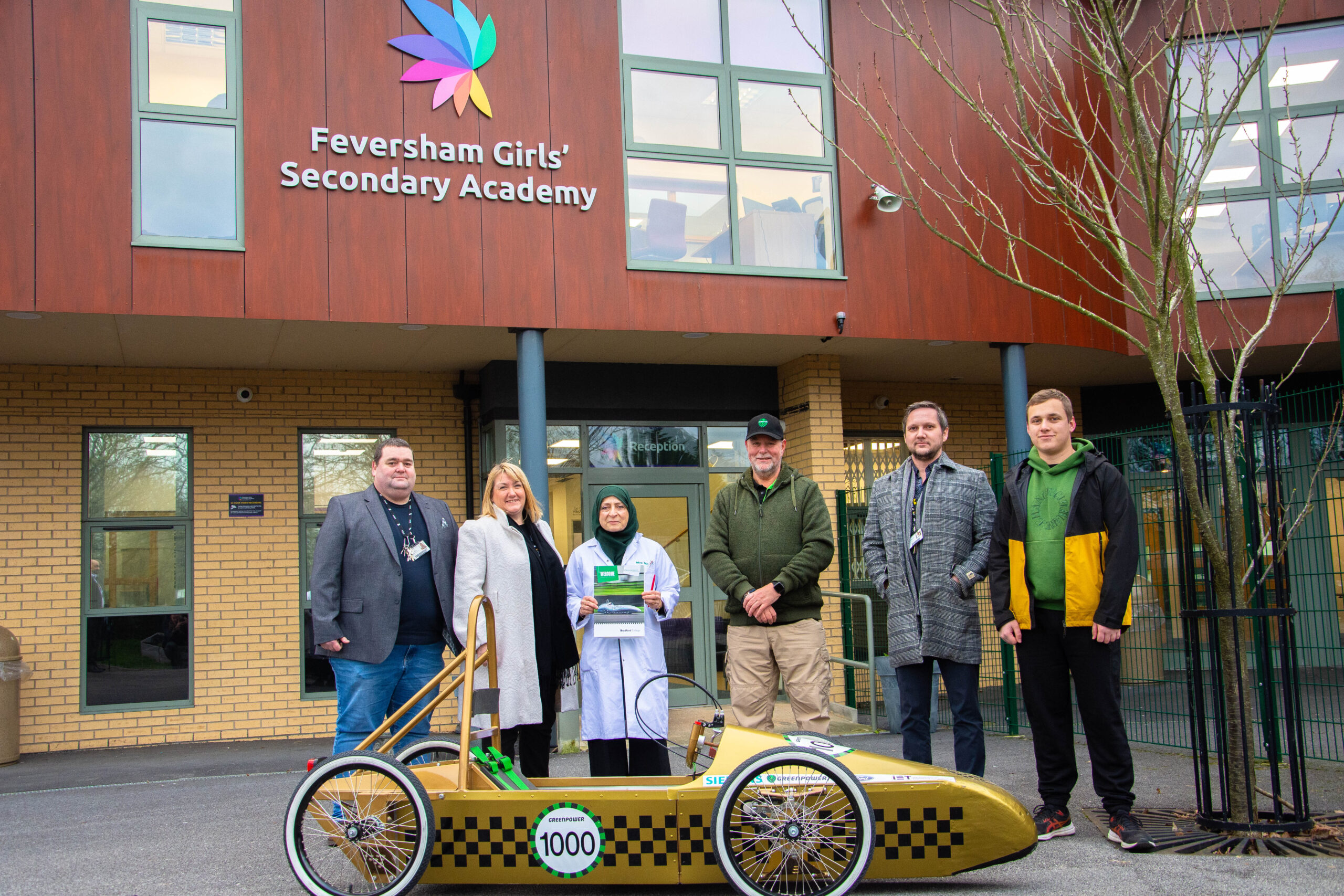 representatives from bradford college, greenpower and feversham girls' secondary academy pictured outside of feversham girls' secondary academy as they deliver a greenpower go kart to the school