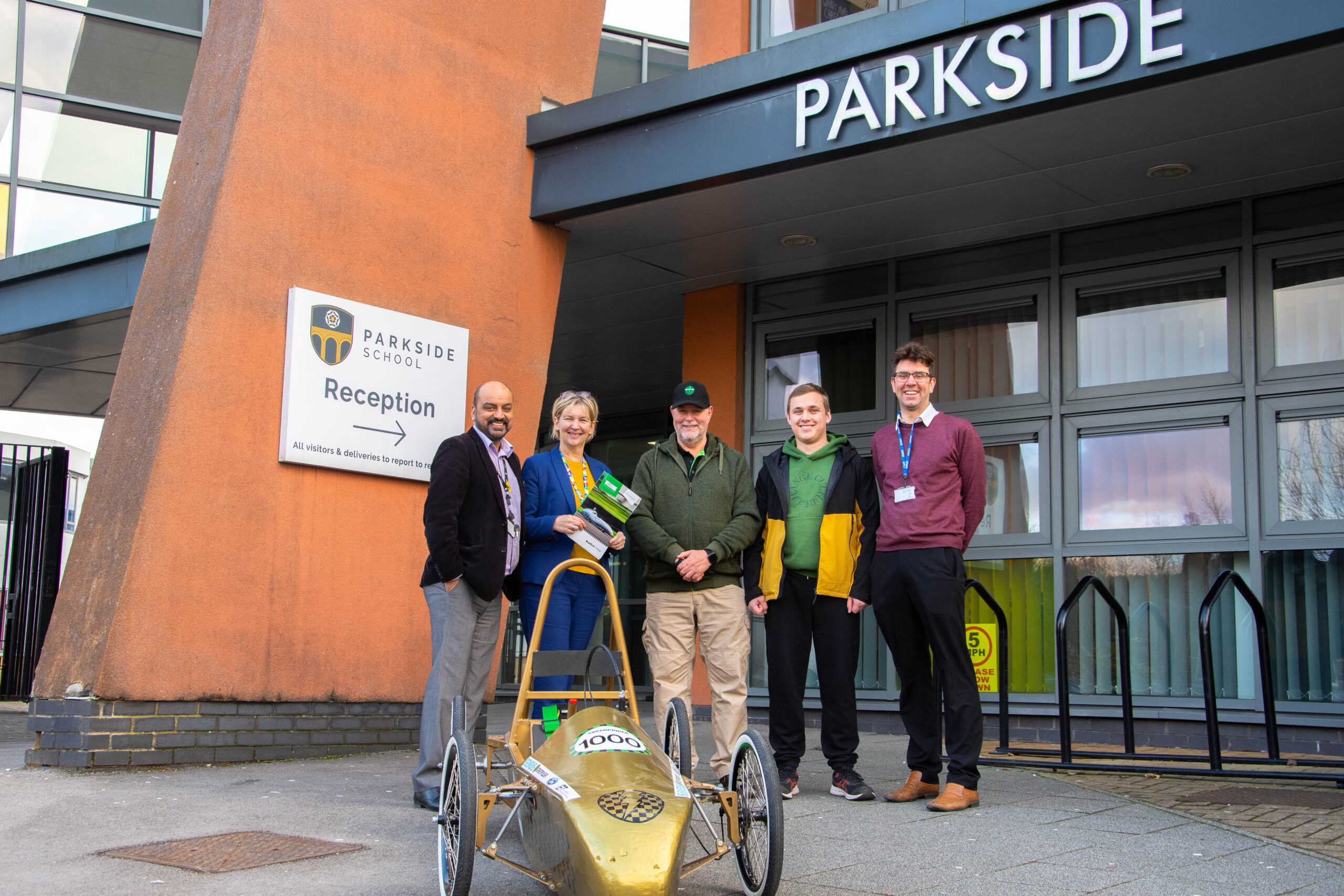 representatives from bradford college, greenpower and parkside school pictured outside of parkside school as they deliver a greenpower go kart to the school