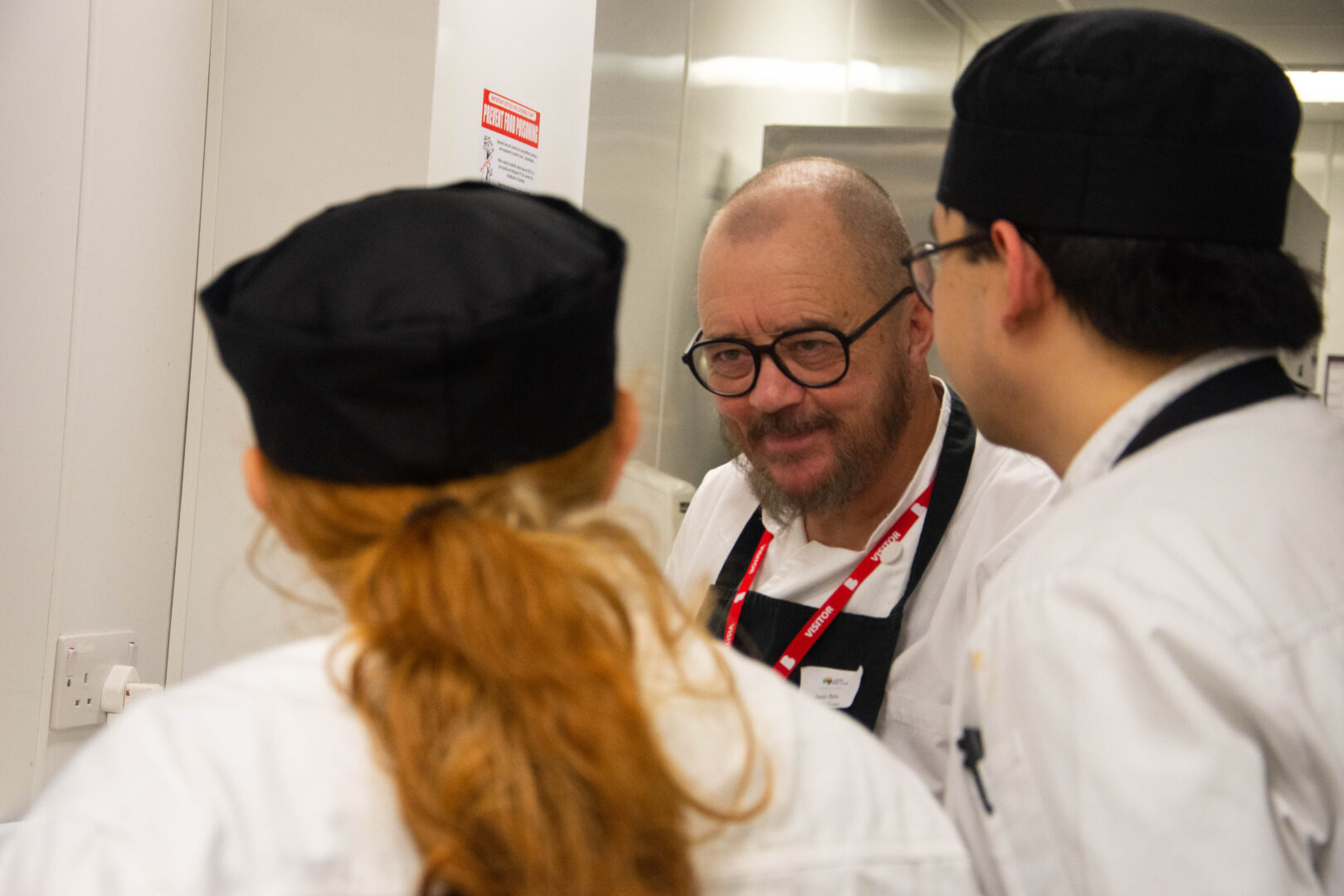 a guest chef smiles as he talks to our catering students