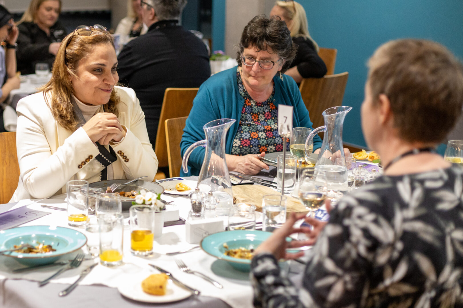 a group of women sit together at a table chatting