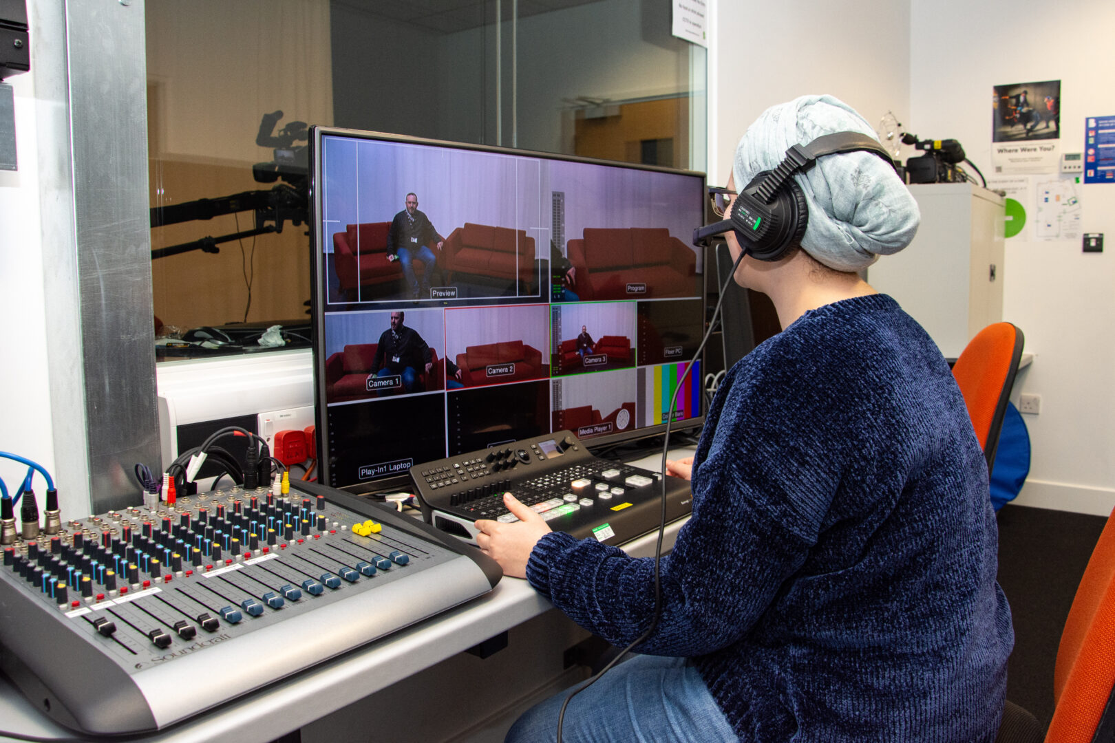 a film student sits at a mixing desk editing television clips