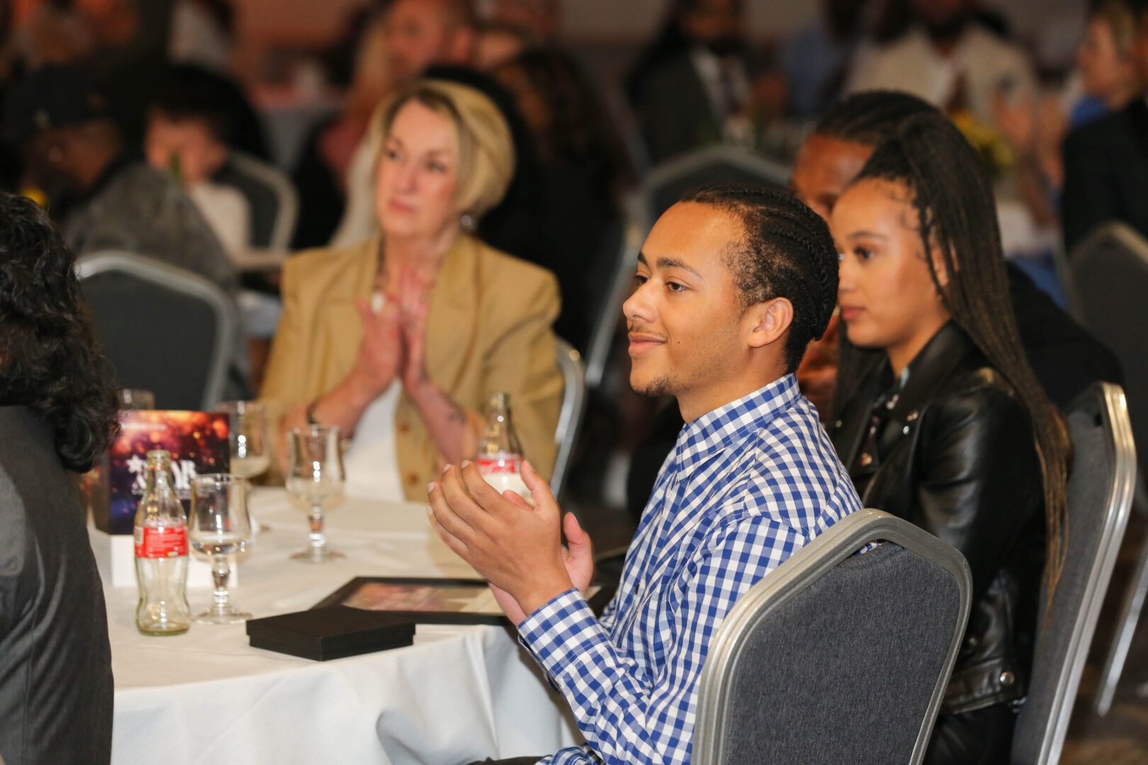 students sit at a table clapping their hands