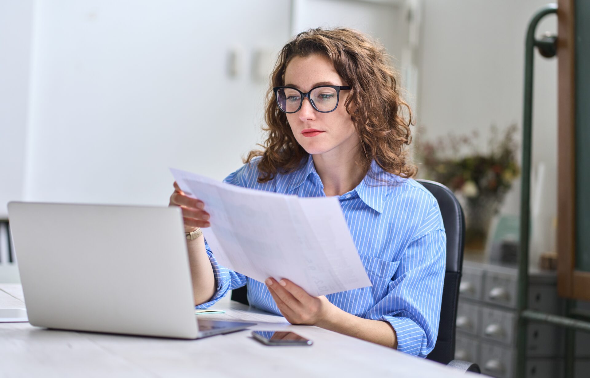 A business woman sat at her desk with paperwork