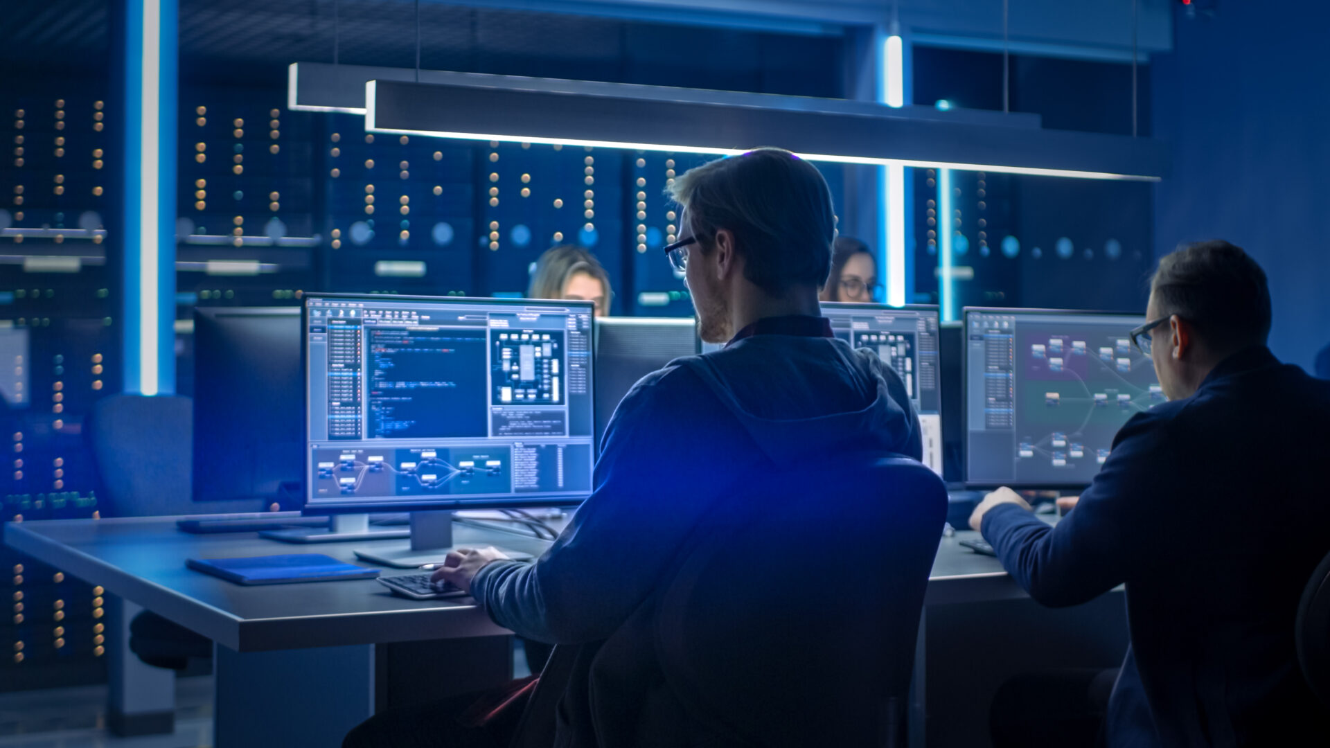 a student sits at a lit up desktop screen working on database design