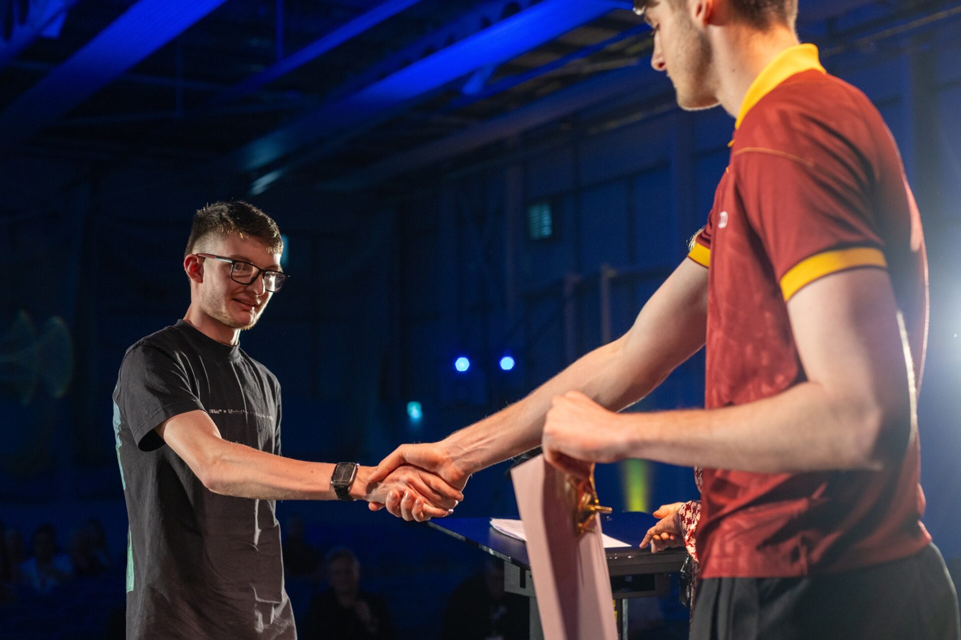 A Bradford United Football Player shaking the hand of a student 