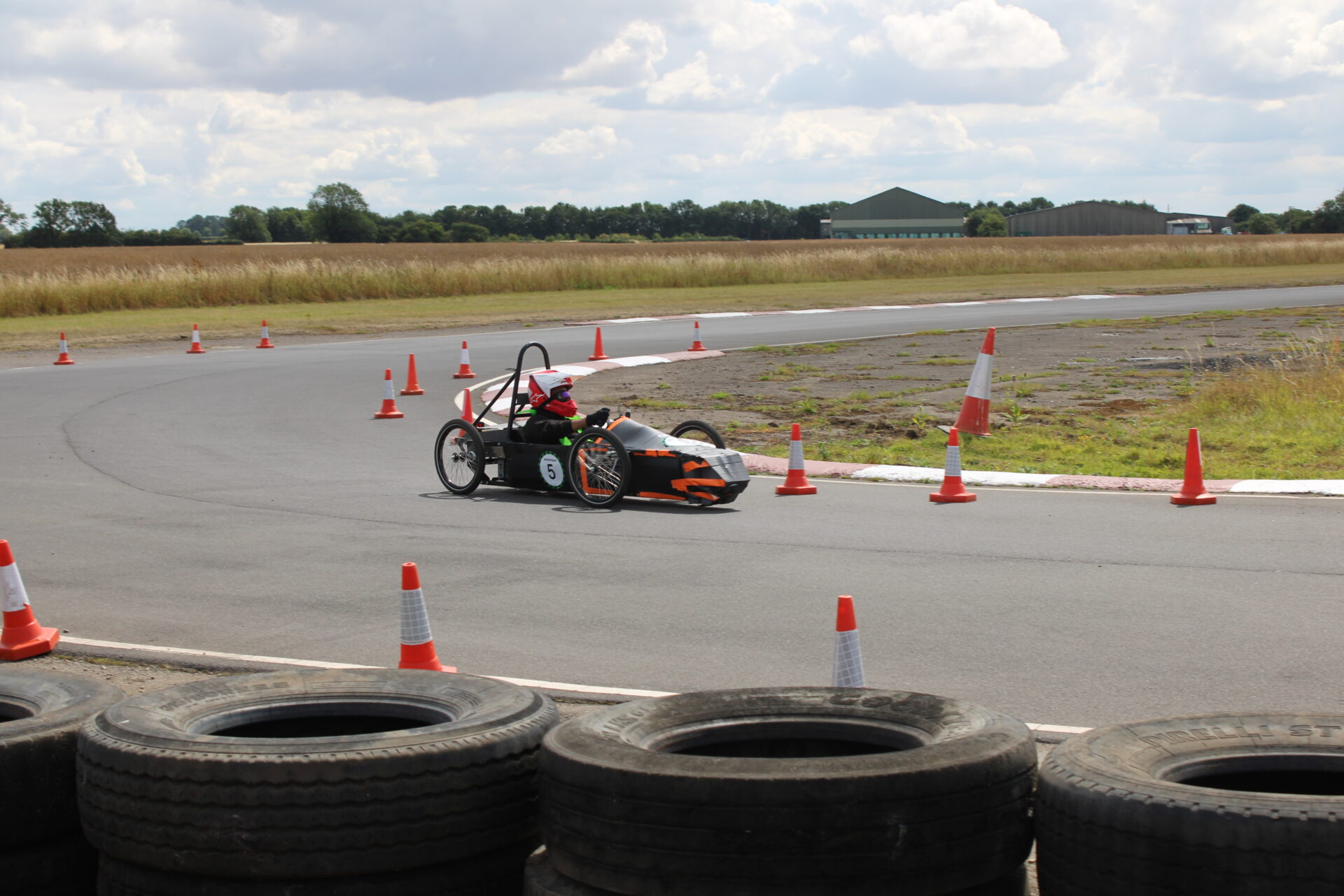 Student driving a greenpower kart on a racetrack