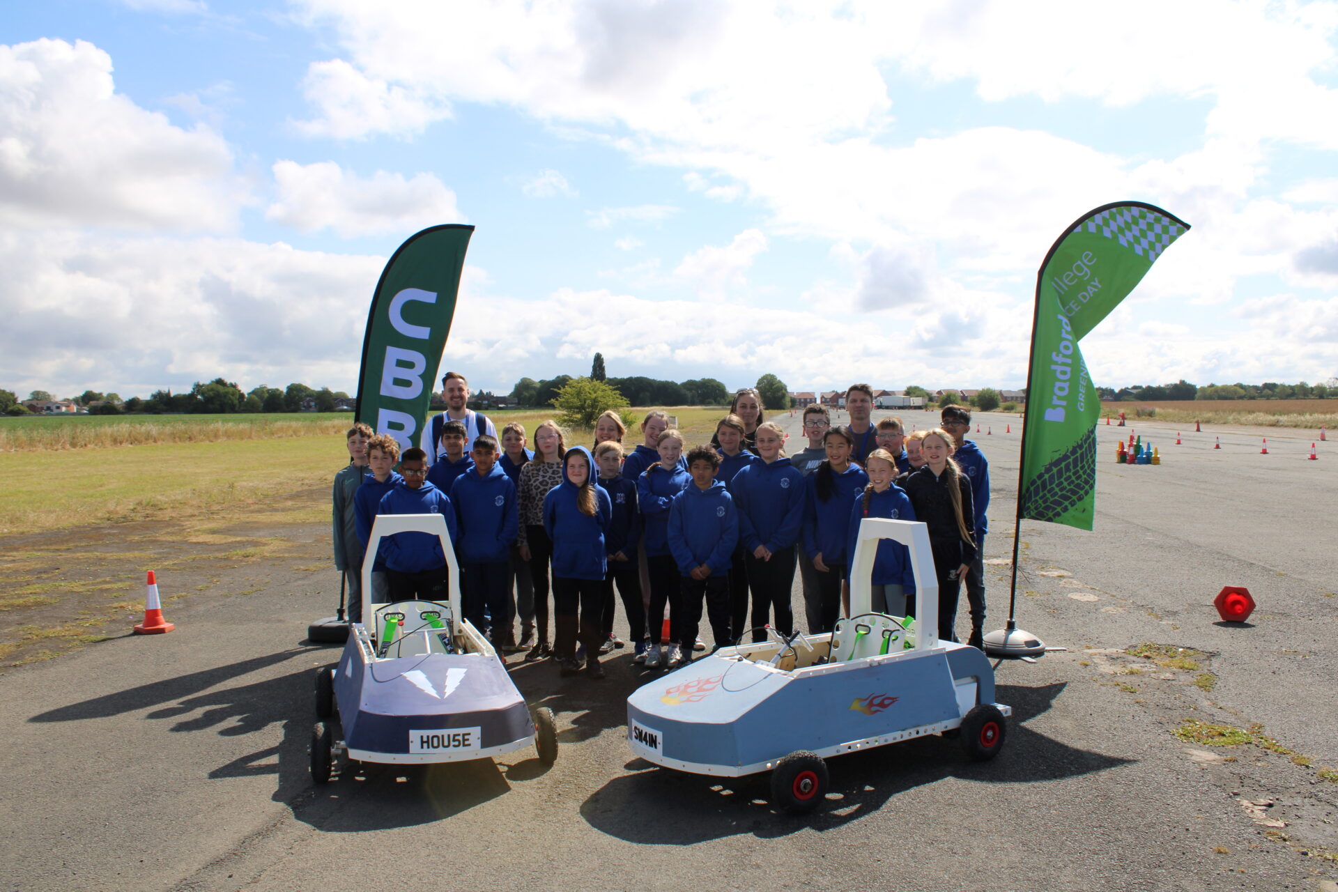 mage of primary school children stood on a racetrack with 2 goblin karts and flags