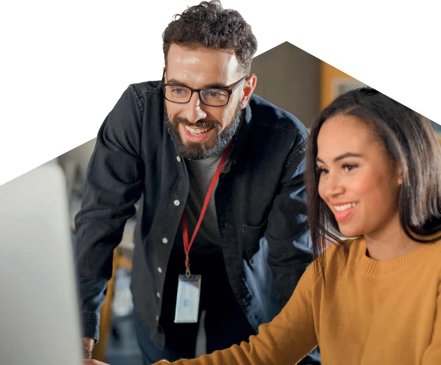 A teacher and student looking at a computer screen smiling